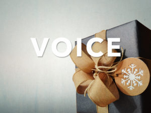 Man in a black coat and carrying a back pack with headphones on his head looking into a busy city street.  The word hear in all caps over the image.