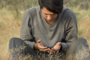 a man praying in a field