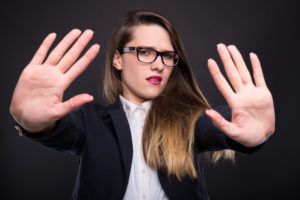 Young beautiful businesswoman with a stop or refusal gesture isolated on dark background